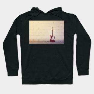 Red electric guitar against white brick wall Hoodie